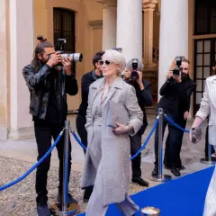 Il cast de "Il diavolo veste Prada" sfila sul red carpet, circondato da paparazzi. Meryl Streep e Anne Hathaway, icone di stile, catturano l'attenzione.