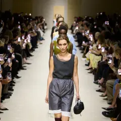 Modella sfila alla Milano Fashion Week 2026, pubblico filma con smartphone.