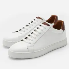 Sneakers bianche in pelle con dettagli marroni. Il loro significato è comfort e stile, perfette per ogni occasione.
