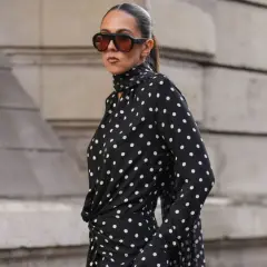 Donna con vestito a pois nero e bianco, occhiali da sole oversize. Come abbinare scarpe a questo look?