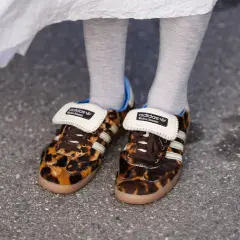 Scarpe leopardate Adidas x Wales Bonner, un outfit audace con calzini grigi e un abito bianco svolazzante.