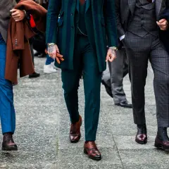 Uomini con abiti eleganti, focus su lunghezza pantalone con mocassino e stivali.