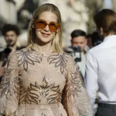 Donna con abito scintillante e occhiali da sole oversize, perfetta per un dress code cocktail donna.