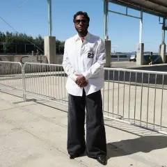 Uomo con camicia bianca e un perfetto abbinamento jeans nero uomo oversize, occhiali da sole e scarpe a punta.