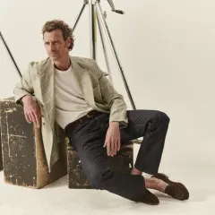 Uomo con un blazer a quadri e jeans scuri, un look fit slim perfetto per ogni occasione.