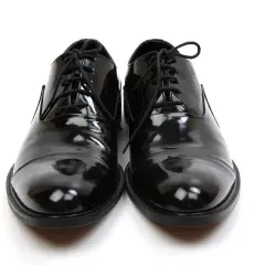 Scarpe smoking nere, lucide e impeccabili, pronte per un'occasione speciale.