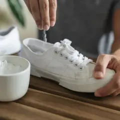 Un rimedio naturale per come togliere puzza dalle scarpe: bicarbonato versato dentro una scarpa bianca.