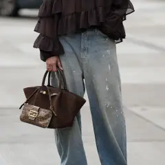 Jeans baggy a chi stanno bene: look casual con blusa a balze e borsa Fendi.