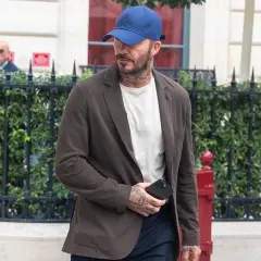 Uomo con cappellino blu e giacca marrone, dimostrando che blu e marrone stanno bene insieme.