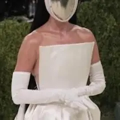 Katy Perry al Met Gala con un abito bianco futuristico e maschera argentata.