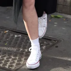 Piedi con calzini bianchi e Converse bianche, un esempio di come lavare le Converse bianche per mantenerle impeccabili.