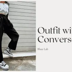 Outfit con Converse alte a righe, pantaloni neri ampi e top bianco. Ecco come allacciare le Converse alte per un look audace.