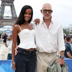 Narah Baptista sorride accanto a Vincent Cassel con la Torre Eiffel e gli anelli olimpici sullo sfondo.