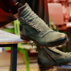 Stivaletti verdi uomo con borchie dorate, un'idea su come abbinare scarpe verdi uomo per un look audace.
