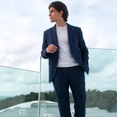 Uomo con completo a quadri blu, maglia bianca e pantaloni blu abbinamento donna.