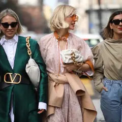 Tre donne sfoggiano un outfit pasqua alla moda: giacca verde smeraldo, abito floreale e top beige con jeans.