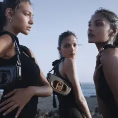 Tre modelle con borse Liu Jo, che marca è? Eleganti e moderne, posano sulla spiaggia con un look total black.