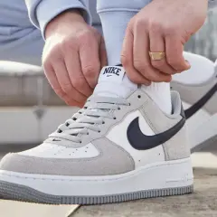 Mani che allacciano le Nike Air Force 1, un classico intramontabile, ricordando quando sono uscite le Air Force 1.