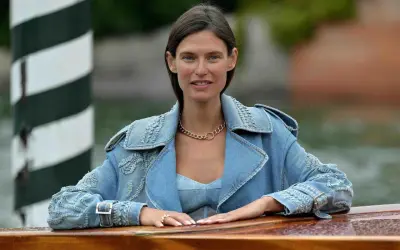 Bianca Balti sorride con un completo di jeans, un cappello dorato e un anello.