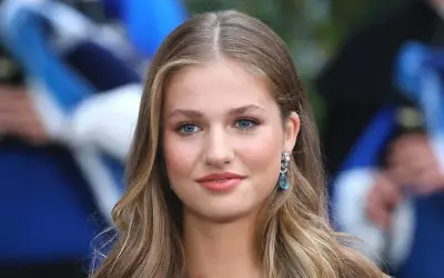 La principessa Leonor, con i suoi occhi azzurri e i capelli biondi, sorride con un elegante orecchino.