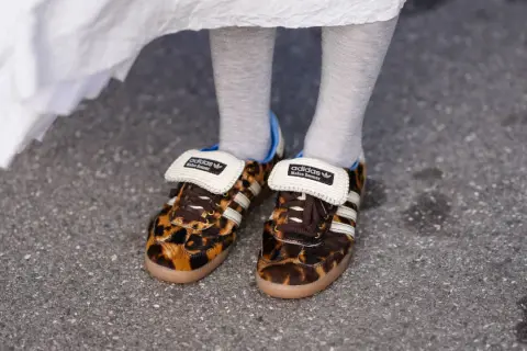 Scarpe leopardate Adidas x Wales Bonner, un outfit audace con calzini grigi e un abito bianco svolazzante.