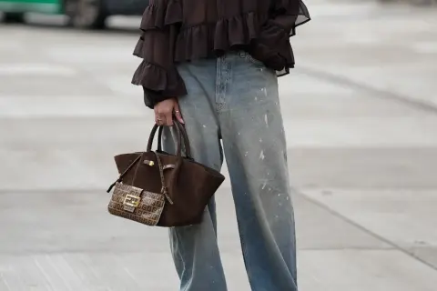 Jeans baggy a chi stanno bene: look casual con blusa a balze e borsa Fendi.