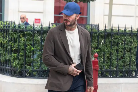 Uomo con cappellino blu e giacca marrone, dimostrando che blu e marrone stanno bene insieme.