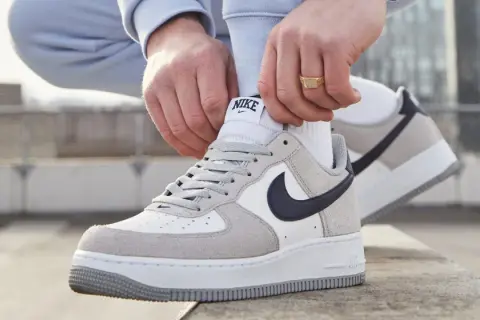 Mani che allacciano le Nike Air Force 1, un classico intramontabile, ricordando quando sono uscite le Air Force 1.