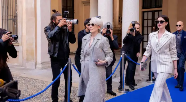 Il cast de "Il diavolo veste Prada" sfila sul red carpet, circondato da paparazzi. Meryl Streep e Anne Hathaway, icone di stile, catturano l'attenzione.