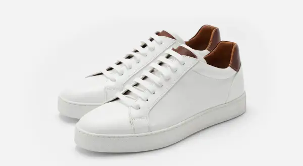 Sneakers bianche in pelle con dettagli marroni. Il loro significato è comfort e stile, perfette per ogni occasione.