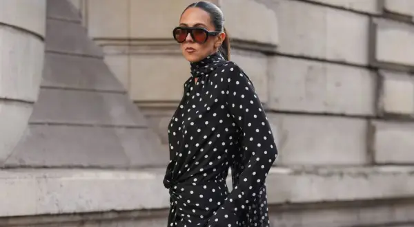 Donna con vestito a pois nero e bianco, occhiali da sole oversize. Come abbinare scarpe a questo look?