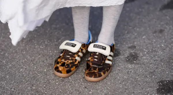 Scarpe leopardate Adidas x Wales Bonner, un outfit audace con calzini grigi e un abito bianco svolazzante.
