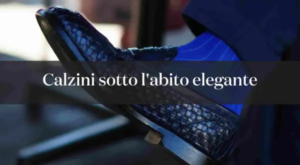 Dettaglio di un elegante abbinamento calze e abito uomo: scarpa in pelle intrecciata e calzino blu a righe.