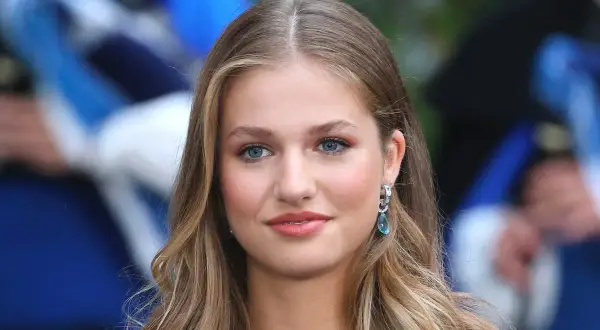 La principessa Leonor, con i suoi occhi azzurri e i capelli biondi, sorride con un elegante orecchino.