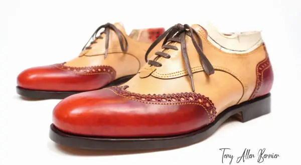 Scarpe Oxford bicolore con tomaia in pelle chiara e inserti rossi. Dettagli traforati e cuciture a vista.