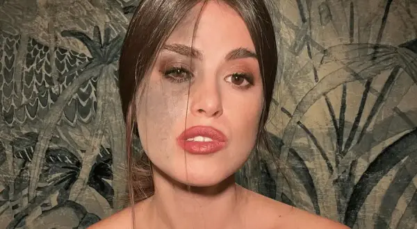 Carlotta Bertotti, con un lato del viso segnato da un neo scuro, guarda intensamente.