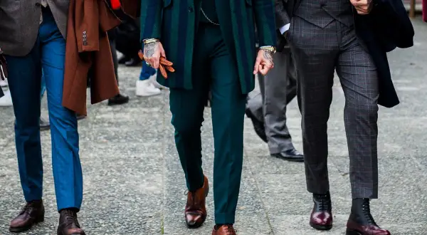 Uomini con abiti eleganti, focus su lunghezza pantalone con mocassino e stivali.