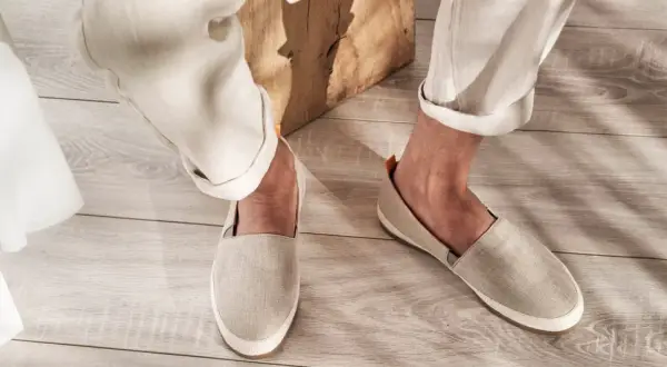 Un uomo indossa un outfit casual con espadrillas uomo in lino beige, pantaloni chiari e un dettaglio in tessuto bianco.