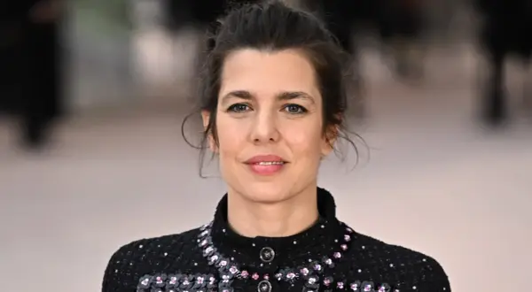 Charlotte Casiraghi, con un'acconciatura raccolta e un abito scuro scintillante, sorride con un'espressione serena.