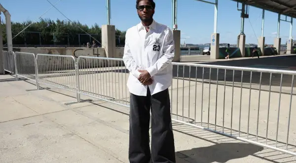 Uomo con camicia bianca e un perfetto abbinamento jeans nero uomo oversize, occhiali da sole e scarpe a punta.
