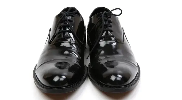 Scarpe smoking nere, lucide e impeccabili, pronte per un'occasione speciale.