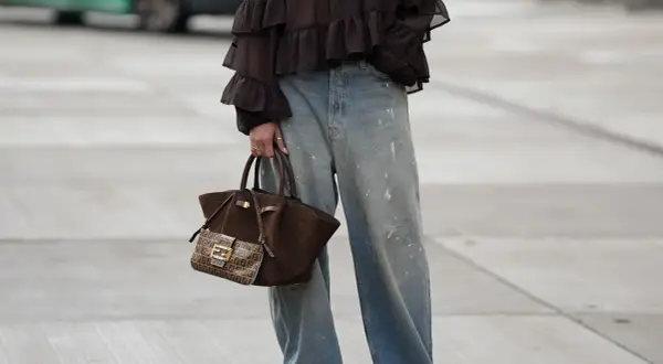 Jeans baggy a chi stanno bene: look casual con blusa a balze e borsa Fendi.