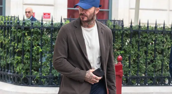 Uomo con cappellino blu e giacca marrone, dimostrando che blu e marrone stanno bene insieme.