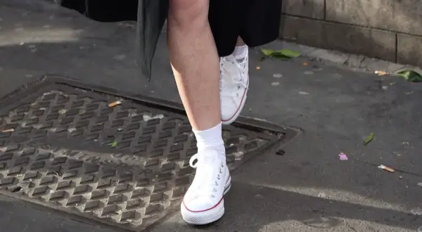 Piedi con calzini bianchi e Converse bianche, un esempio di come lavare le Converse bianche per mantenerle impeccabili.