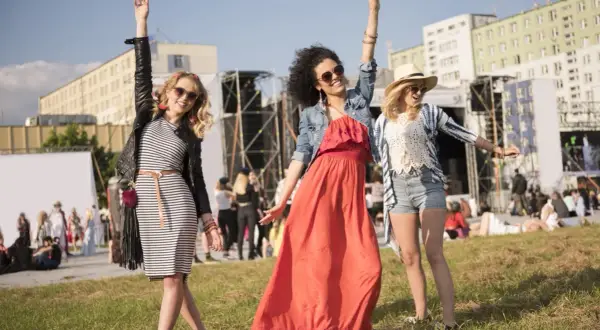 Tre amiche festeggiano a un concerto estivo: abiti leggeri, giacche e cappelli per sapere come vestirsi ad un concerto estate.
