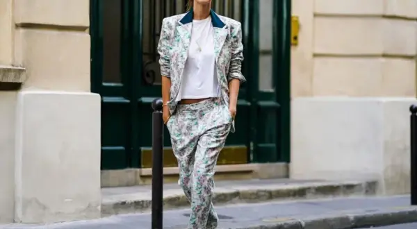 Un outfit da colloquio di lavoro senza tacchi: tailleur floreale con blazer e pantaloni ampi, t-shirt bianca e sneakers.