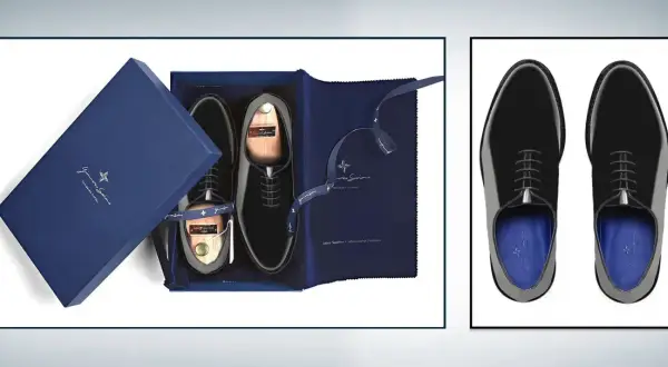 Eleganti scarpe smoking nere lucide, presentate in una scatola blu con accessori e calzascarpe in legno.