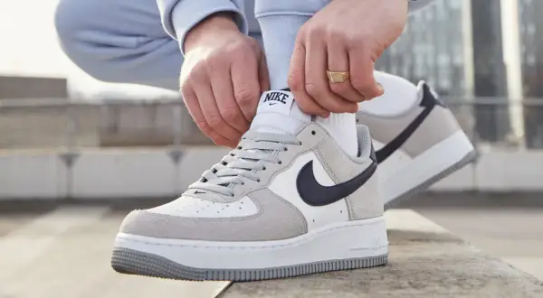 Mani che allacciano le Nike Air Force 1, un classico intramontabile, ricordando quando sono uscite le Air Force 1.