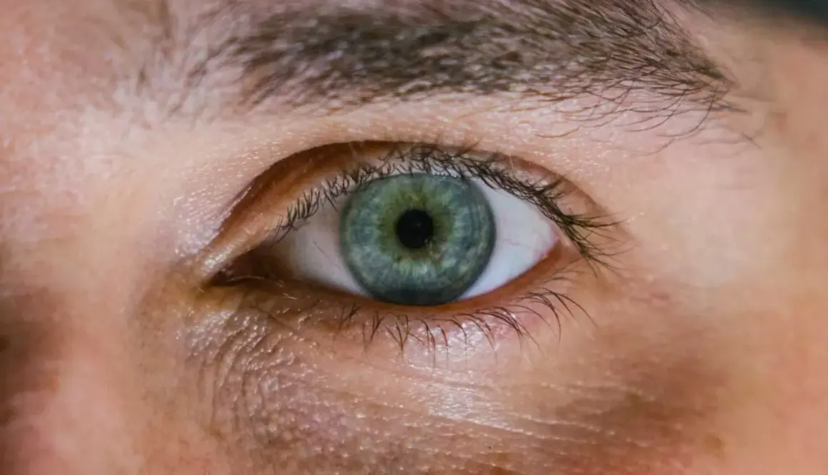 Occhio con iride verde-blu e segni di stanchezza sotto. Scopri come far sparire le occhiaie per uno sguardo più riposato.