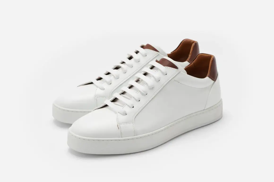 Sneakers bianche in pelle con dettagli marroni. Il loro significato è comfort e stile, perfette per ogni occasione.
